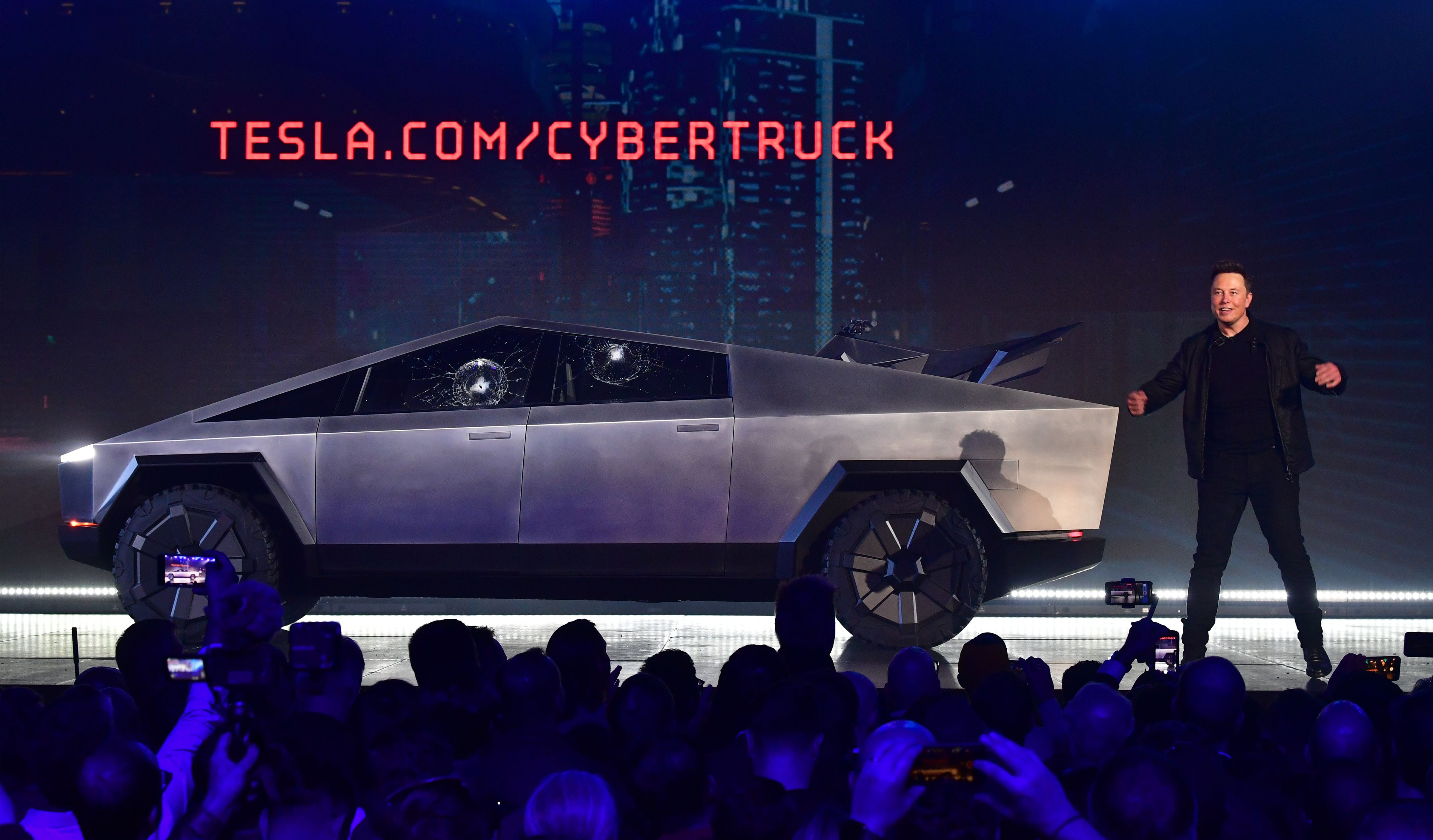 Elon Musk debout devant le Cybertruck avec deux vitres cassées lors de la présentation du véhicule